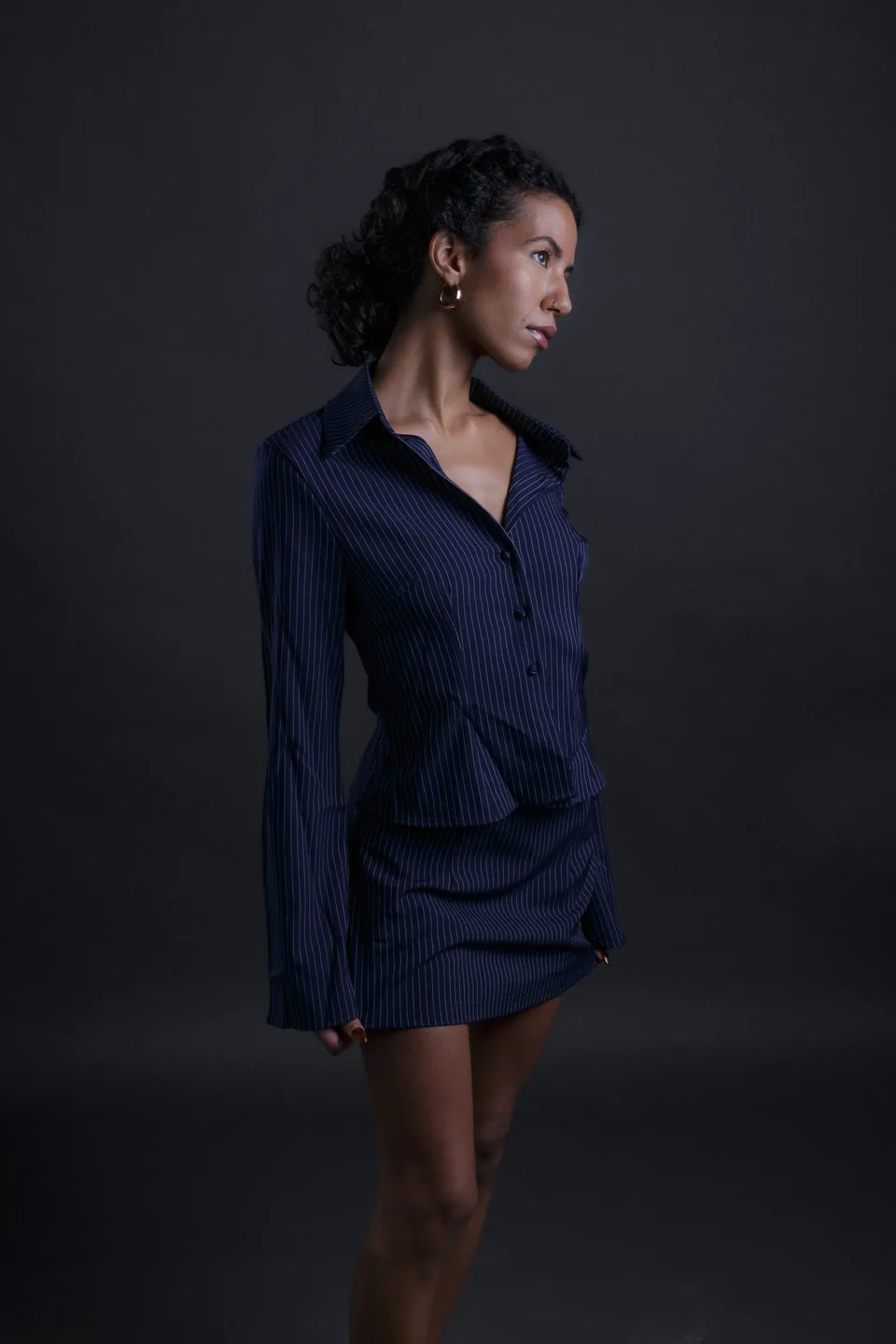 Studio fashion portrait of a model in a navy pinstripe outfit