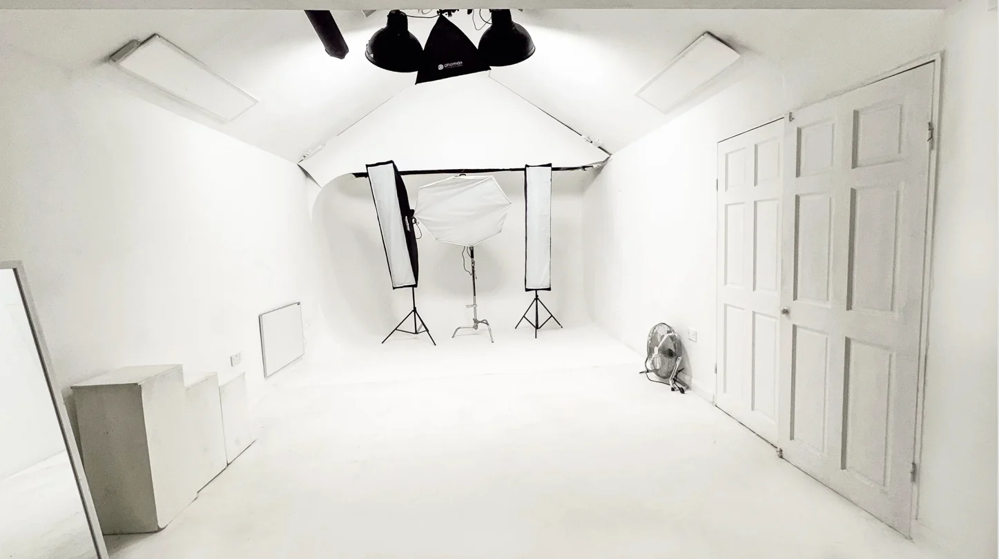 Bright white photography studio with an infinity wall and studio lighting
